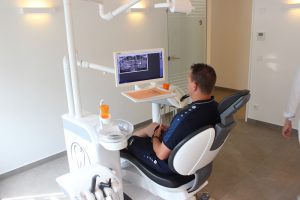 Patient schaut sich Röntgenaufnahmen beim Zahnarzt an